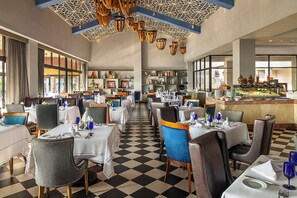A restaurant with checkered flooring, multiple tables with chairs, and a buffet area.