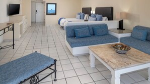 Una habitación de hotel con cama, sofá, mesa y televisor.