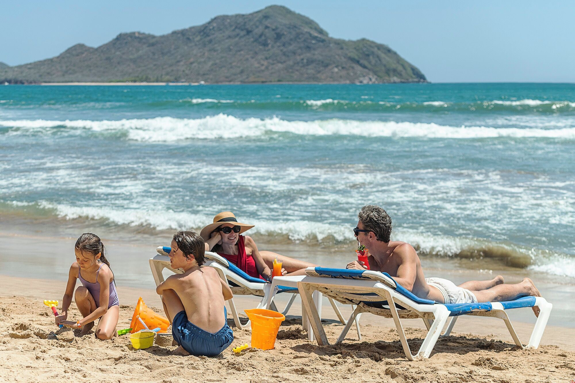 En la playa, sillas reclinables de playa, sombrillas, toallas de playa