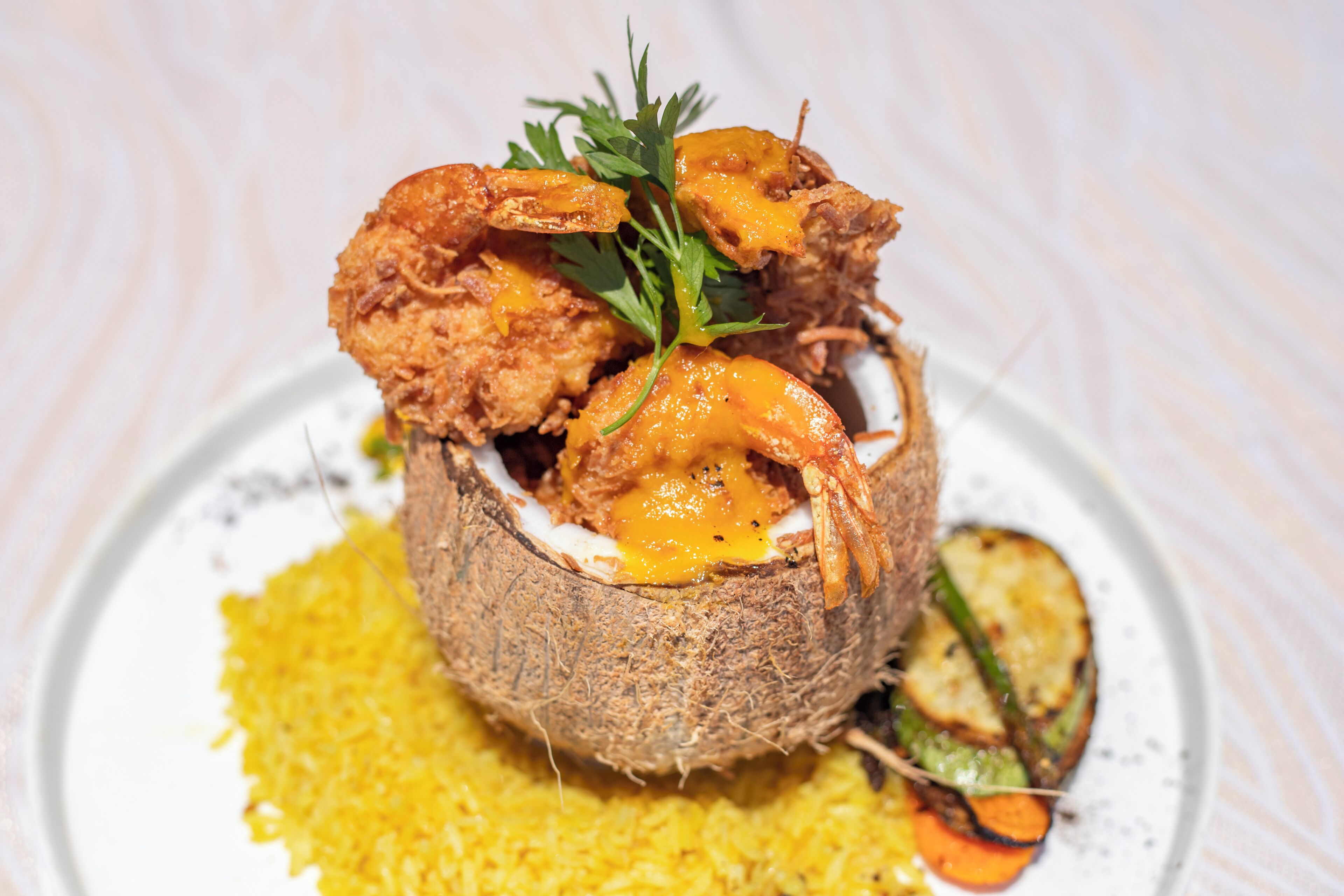Un plato con camarones fritos, un huevo cocido y una guarnición.