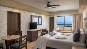 A hotel room with a bed, a desk, a television, a window with a view, and a ceiling fan. - El Cid El Moro Beach Hotel (Mazatlán)