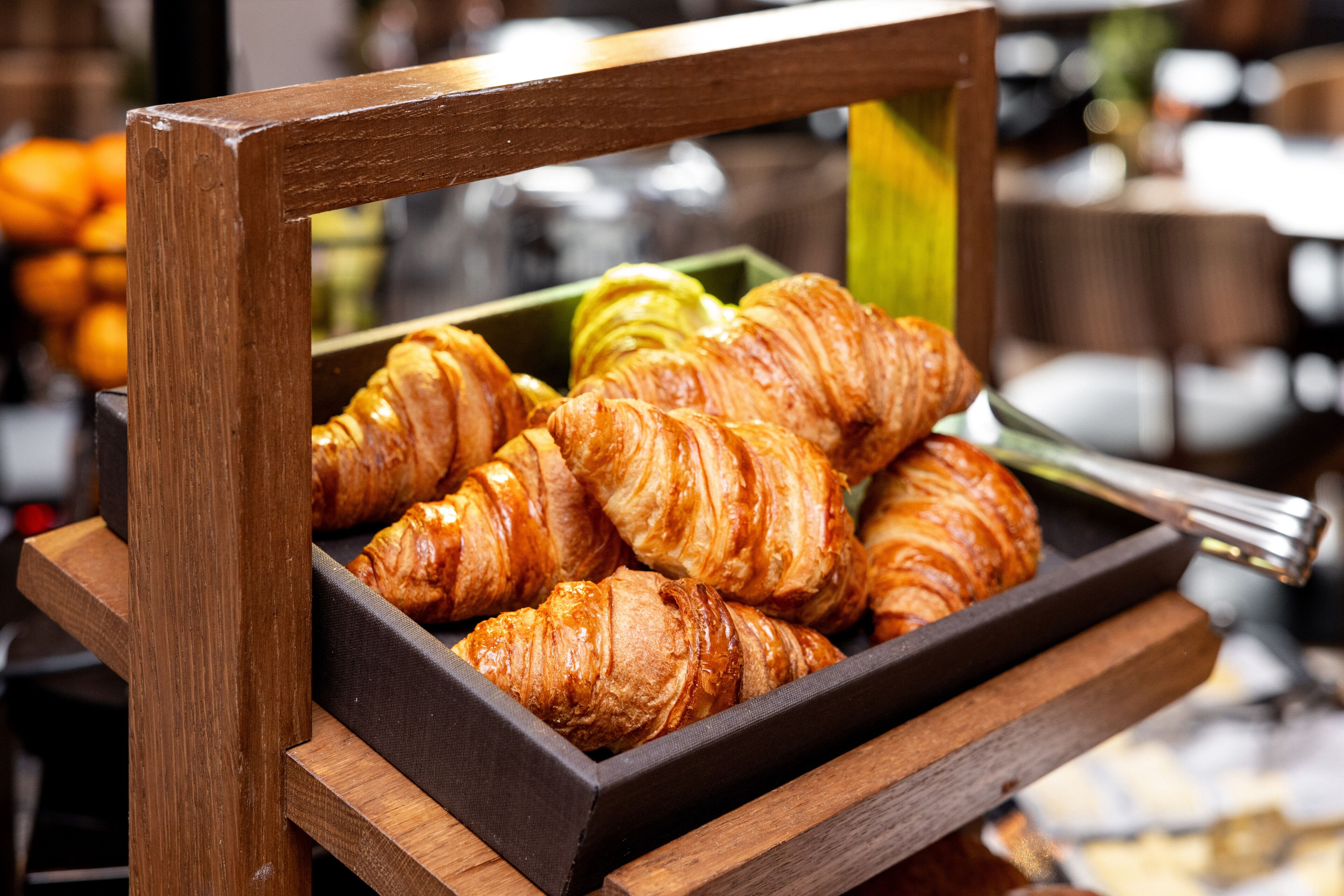 Una vitrina de madera con una bandeja que contiene croissants.