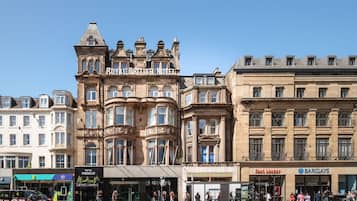 A historic building with a prominent "Royal British Hotel" sign, featuring classical architecture with ornate detailing and multiple windows.