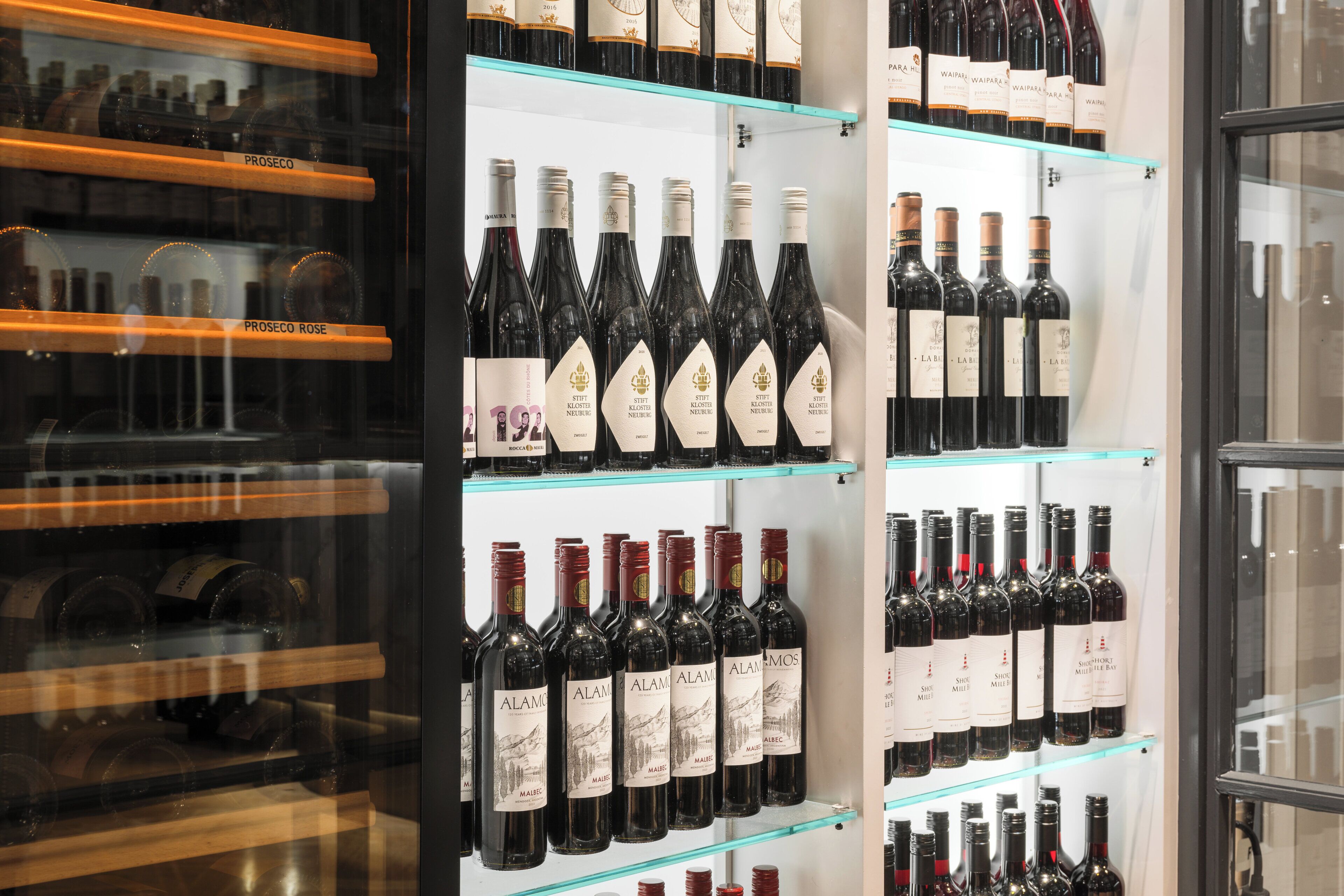 A wine rack with bottles labeled 'PROSECO' and 'ALAMO.'