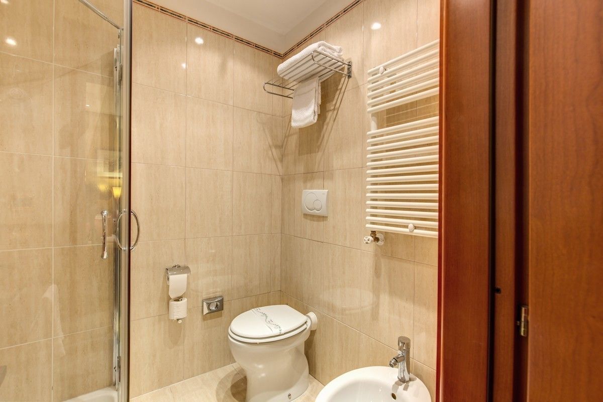 A modern bathroom with a glass shower enclosure, a toilet, and a sink.