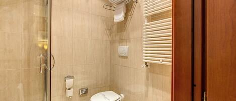 A modern bathroom with a glass shower enclosure, a toilet, and a sink.