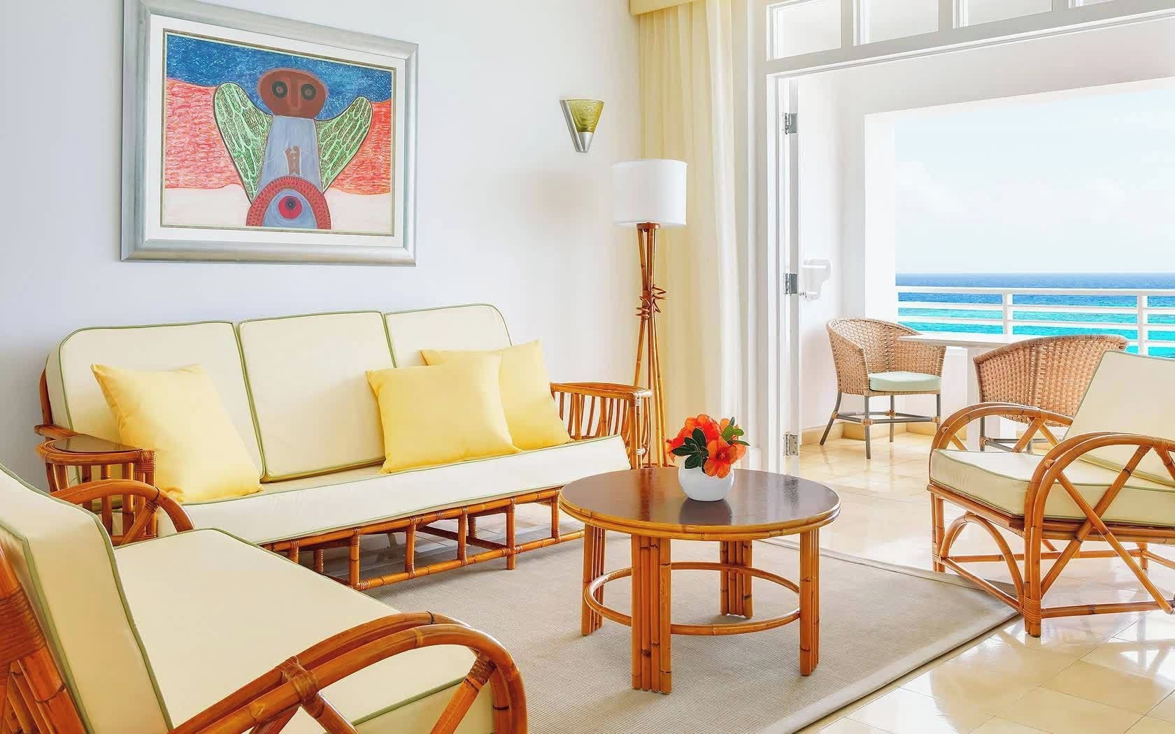 Une pièce comprenant un canapé, des fauteuils, une table et un tableau accroché au mur.