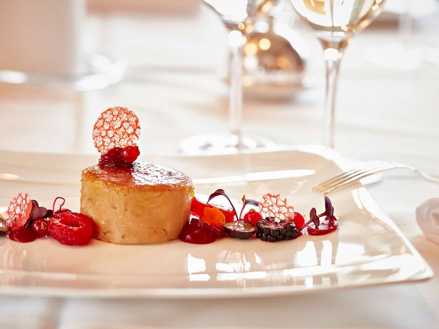 Un postre sobre un plato blanco, con un tenedor al lado.