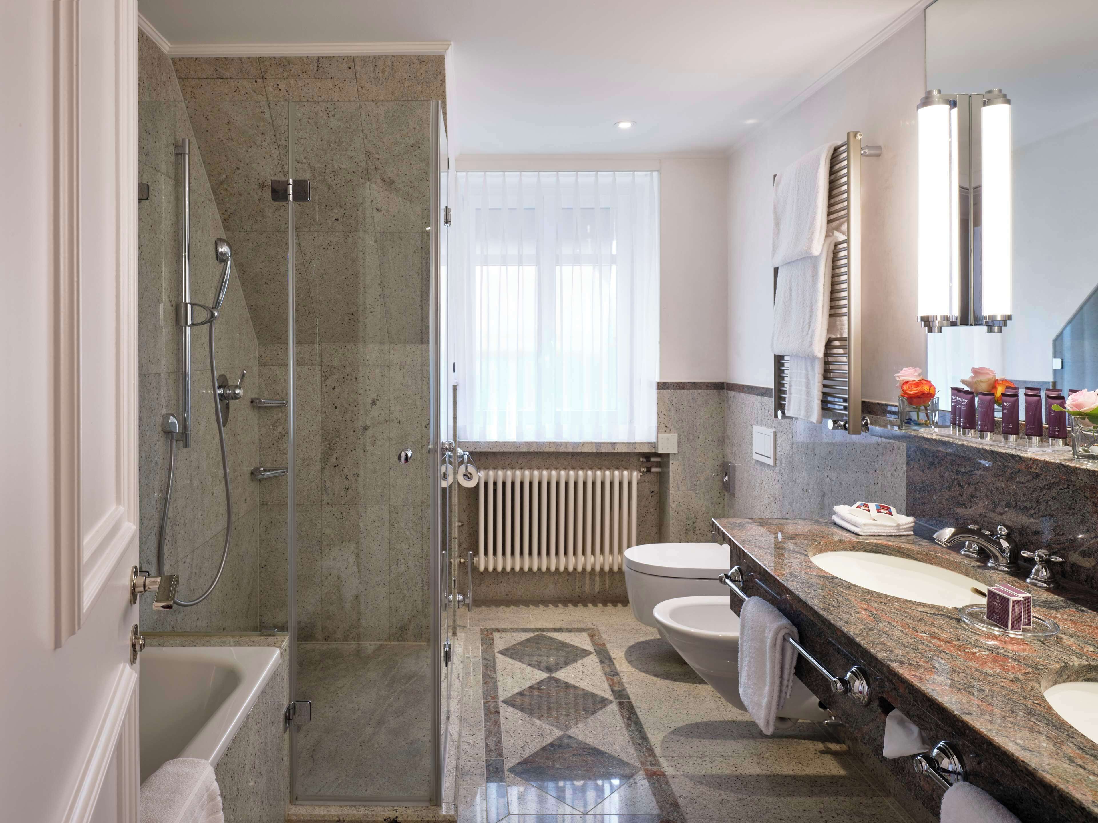 A modern bathroom with a shower, toilet, and sink.