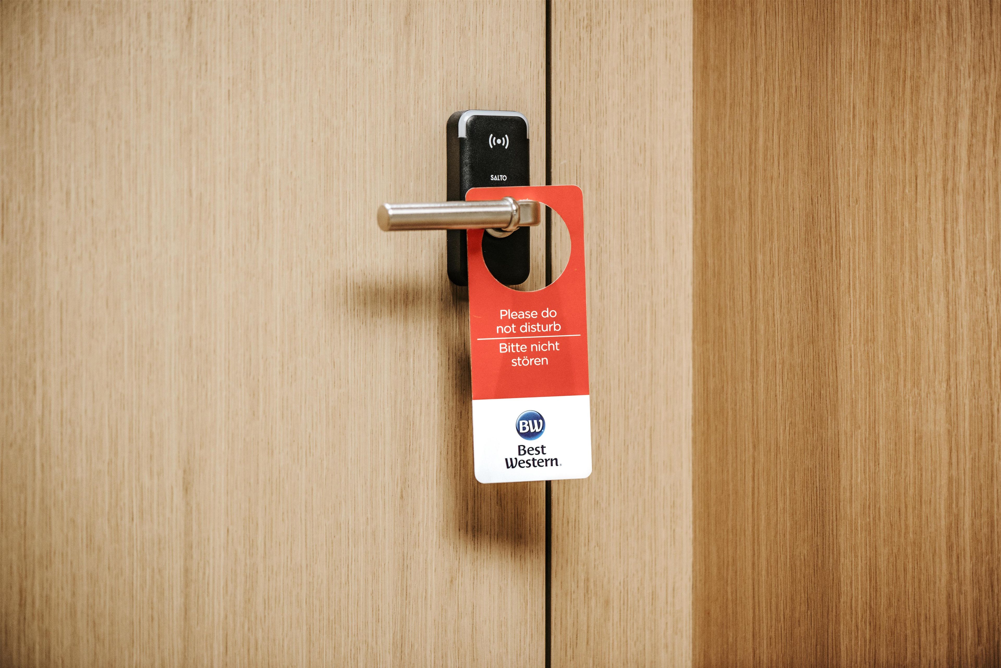 A door with a keyhole and a red card with text and a logo.