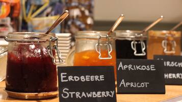 Jars of fruit preserves with labels indicating flavors like strawberry and apricot.
