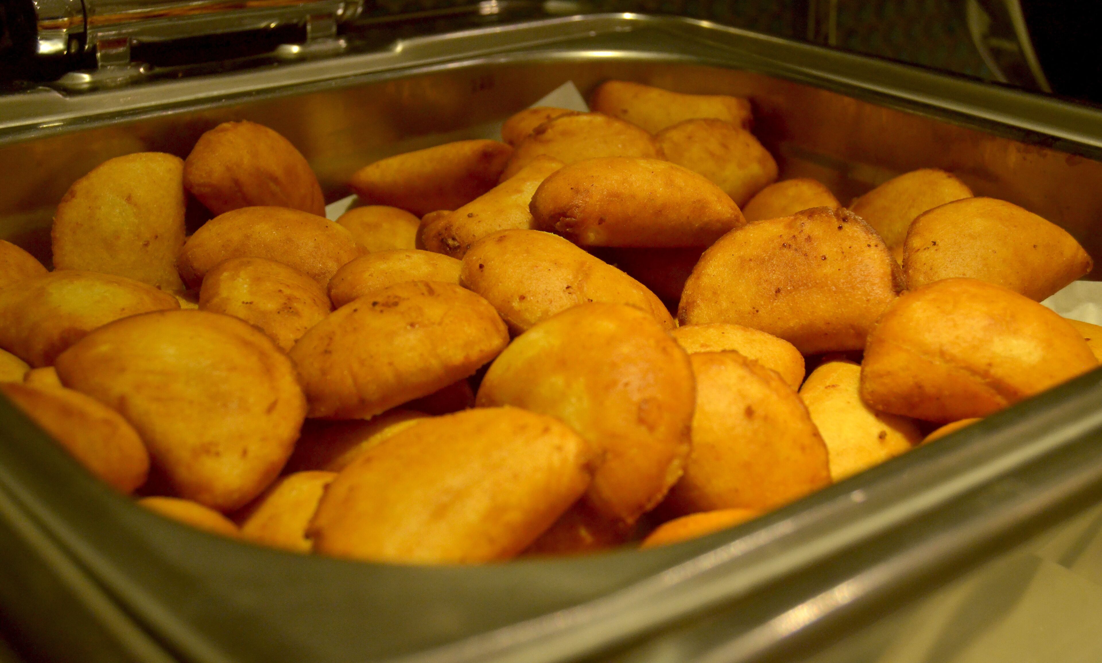 A buffet with a variety of golden-brown pastries.