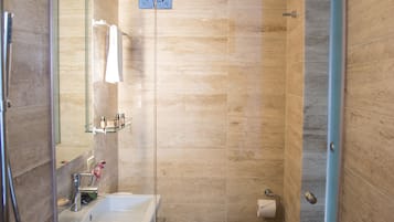 A modern bathroom with a glass shower enclosure, a sink, and a toilet.