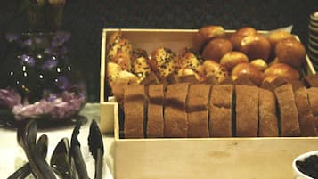 A wooden box containing sliced bread and various pastries.