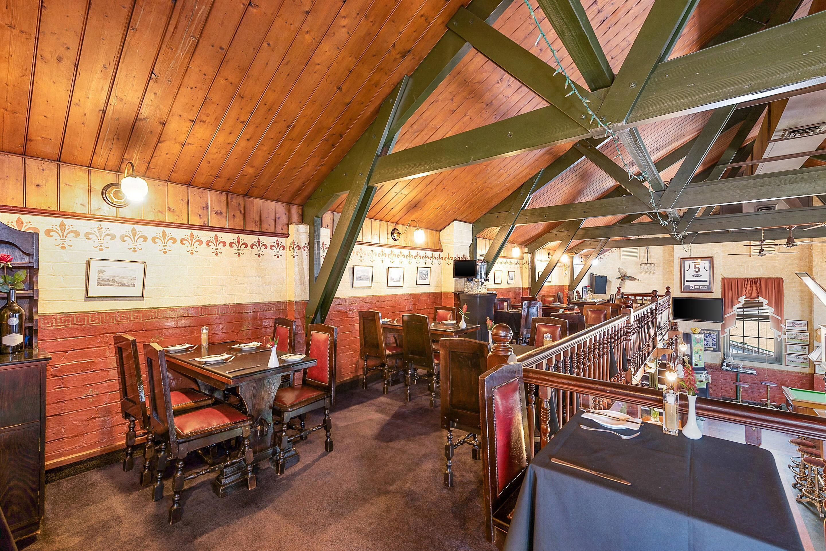 A restaurant with wooden beams, red brick walls, and traditional wooden furniture.