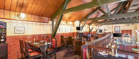 A restaurant with wooden beams, red brick walls, and traditional wooden furniture.