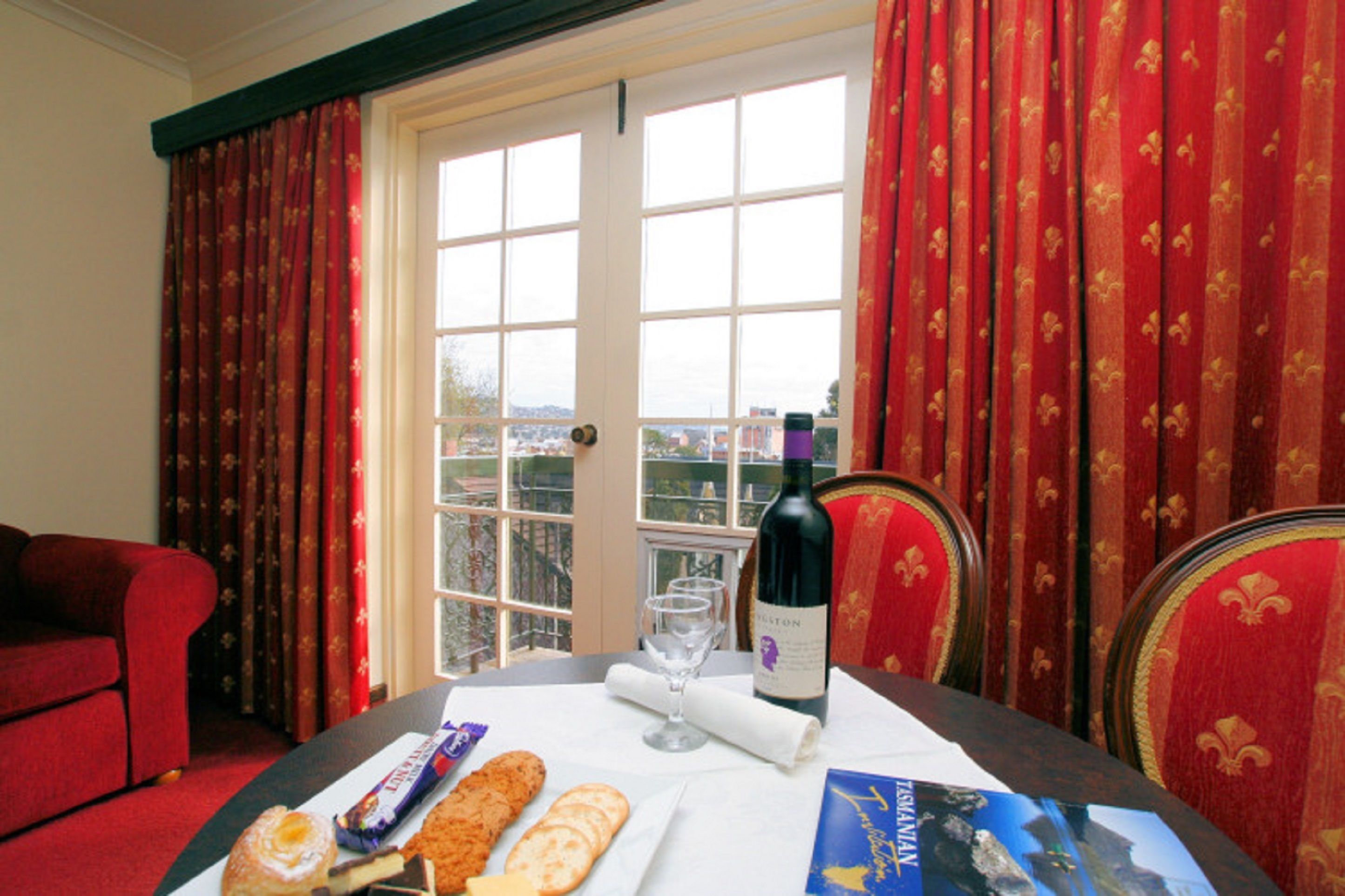 A dining table with a bottle of wine, glasses, and a menu.