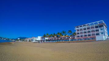 En la playa, playa de arena blanca, sombrillas y toallas de playa