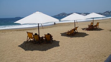 On the beach, white sand, beach umbrellas, beach towels