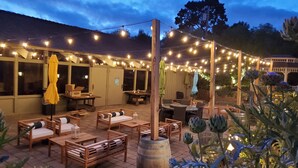 An outdoor patio area with wooden furniture, string lights, and potted plants. - Carmel Valley Lodge and Resort (Carmel Valley)