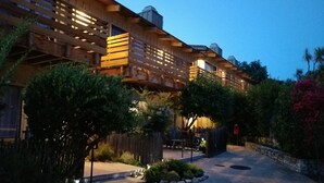 A modern building with a wooden facade and a stone pathway leading to the entrance. - Carmel Valley Lodge and Resort (Carmel Valley)