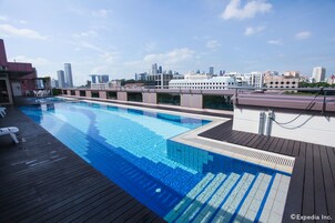 A rooftop swimming pool with a city skyline view.
