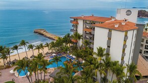 Hotel com piscina, praia e vista para o oceano.