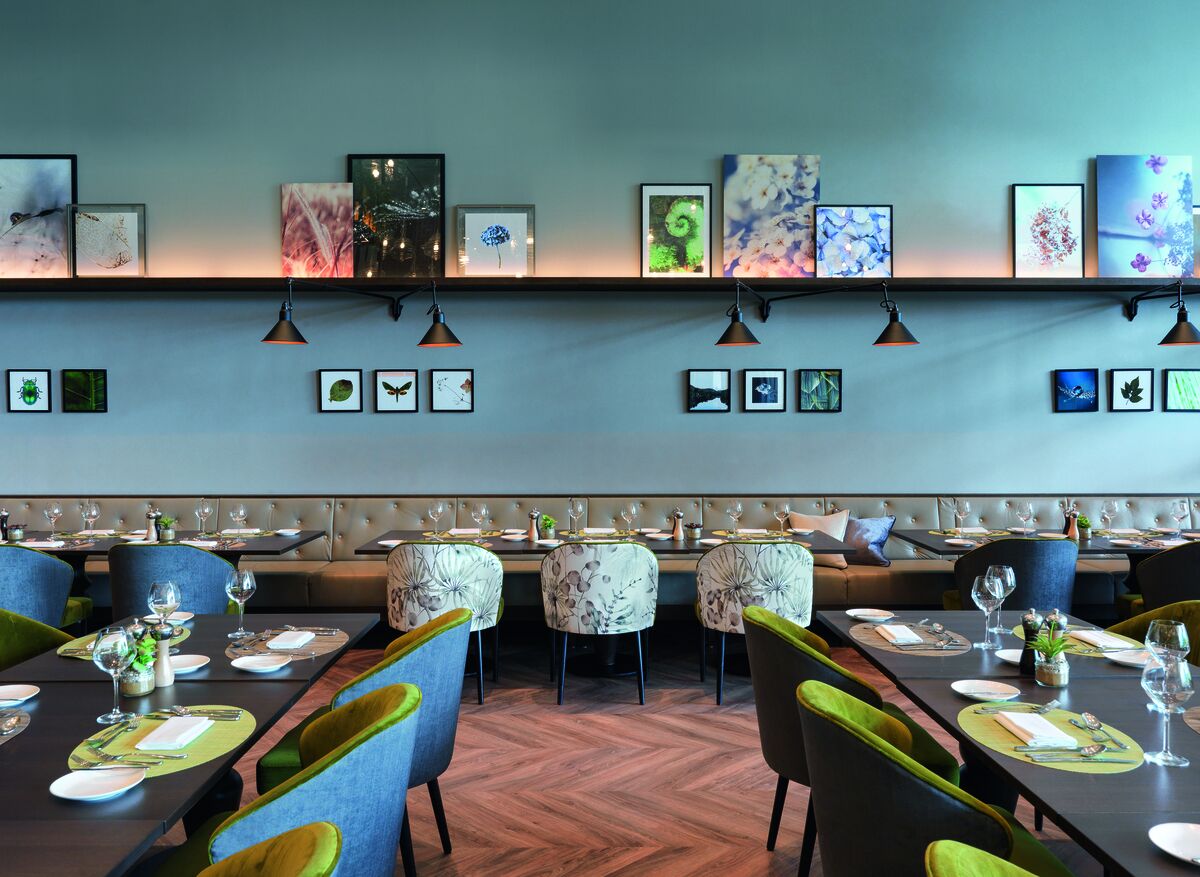 A restaurant with a long dining table, chairs, and a bench seating area.