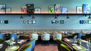A restaurant with a long dining table, chairs, and a bench seating area.
