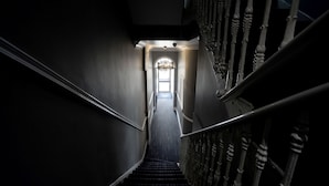 A narrow staircase with ornate balusters and a dark carpet leading to a door at the top. - The 29 London (London)