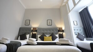 A hotel room with a large bed, two bedside tables with lamps, a headboard, and two framed pictures on the wall. - The 29 London (London)