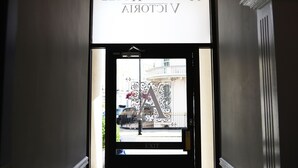 Ein Hinweisschild für das Hotel JERUSAH HOTEL VICTORIA mit einer verzierten Glastür, die einen großen Buchstaben 'A' zeigt.
