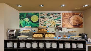 Un bufé de desayuno con diferentes alimentos y una máquina de café.