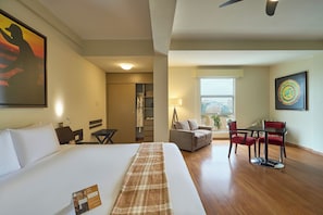 A hotel room with a bed, a desk, a chair, a sofa, a window, and a painting on the wall. - Casa Andina Select Chiclayo (Chiclayo)