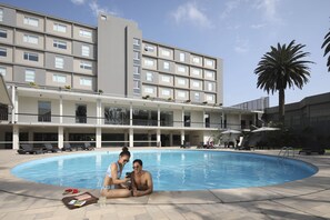 Una piscina al aire libre, tumbonas