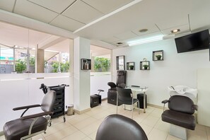 A salon with multiple seating areas, a mirror, and a television on the wall. - Casa Andina Select Chiclayo (Chiclayo)