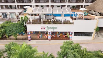 Relax and socialize in the hotel's spacious outdoor dining area, featuring comfortable seating and a refreshing pool.
