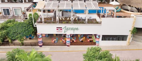 A hotel with a rooftop bar, outdoor seating, and a pool.