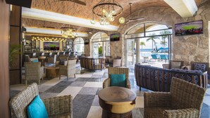 Un hall d’entrée spacieux, doté de meubles en osier, d’un bar et offrant une vue sur la plage.