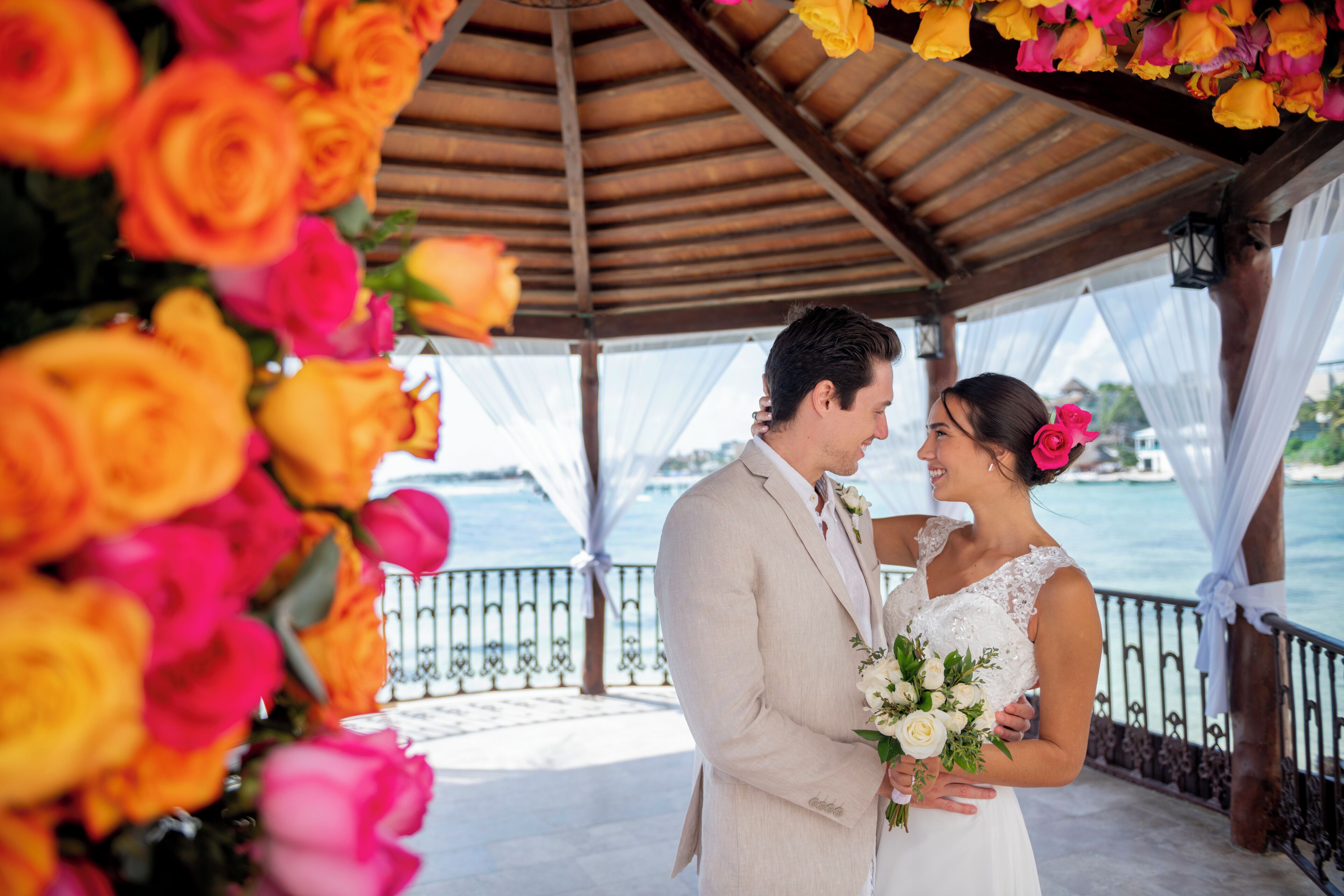 Un couple assis sous une pergola, avec vue sur la mer.