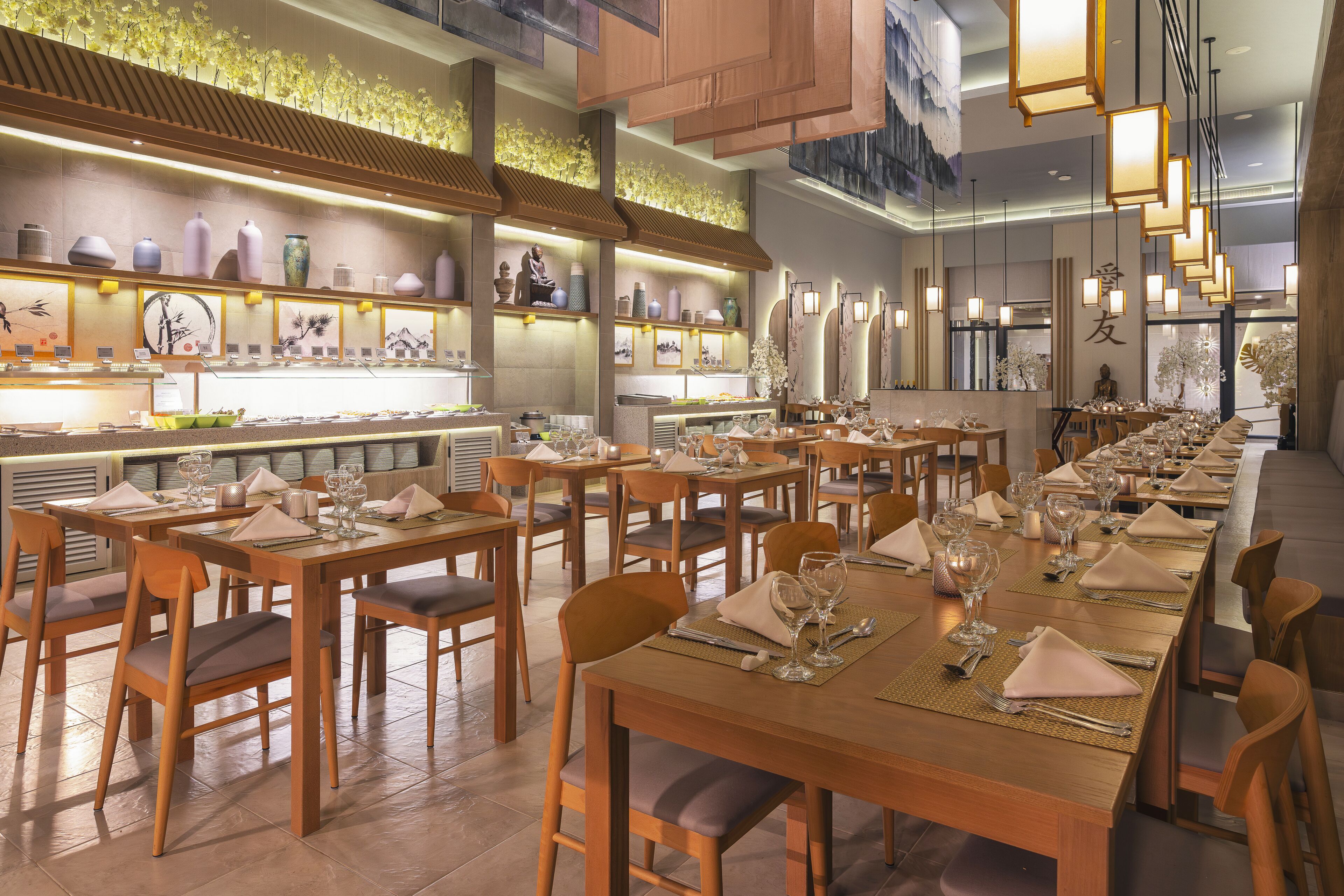 A restaurant with wooden tables and chairs, neatly set with tableware.