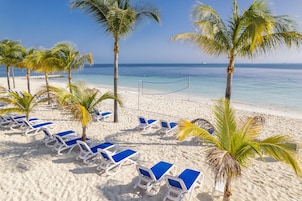 On the beach, white sand, sun loungers, beach umbrellas