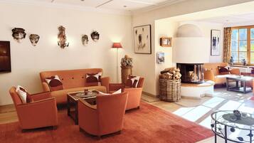 A living room with a sofa set, a fireplace, and wall-mounted art.