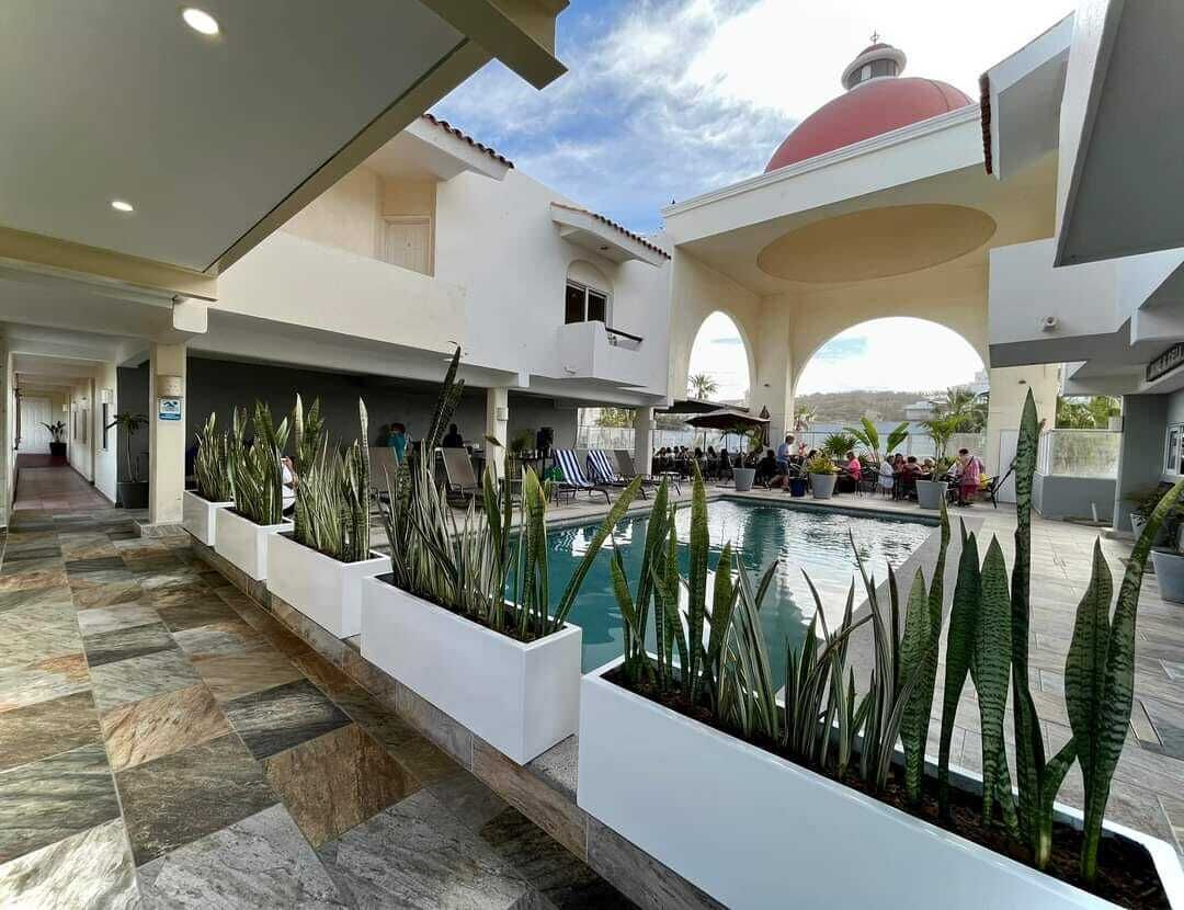 A pool area with planters and lounge chairs.