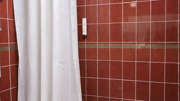 Un baño con una bañera blanca, un lavamanos blanco y una cortina de ducha.