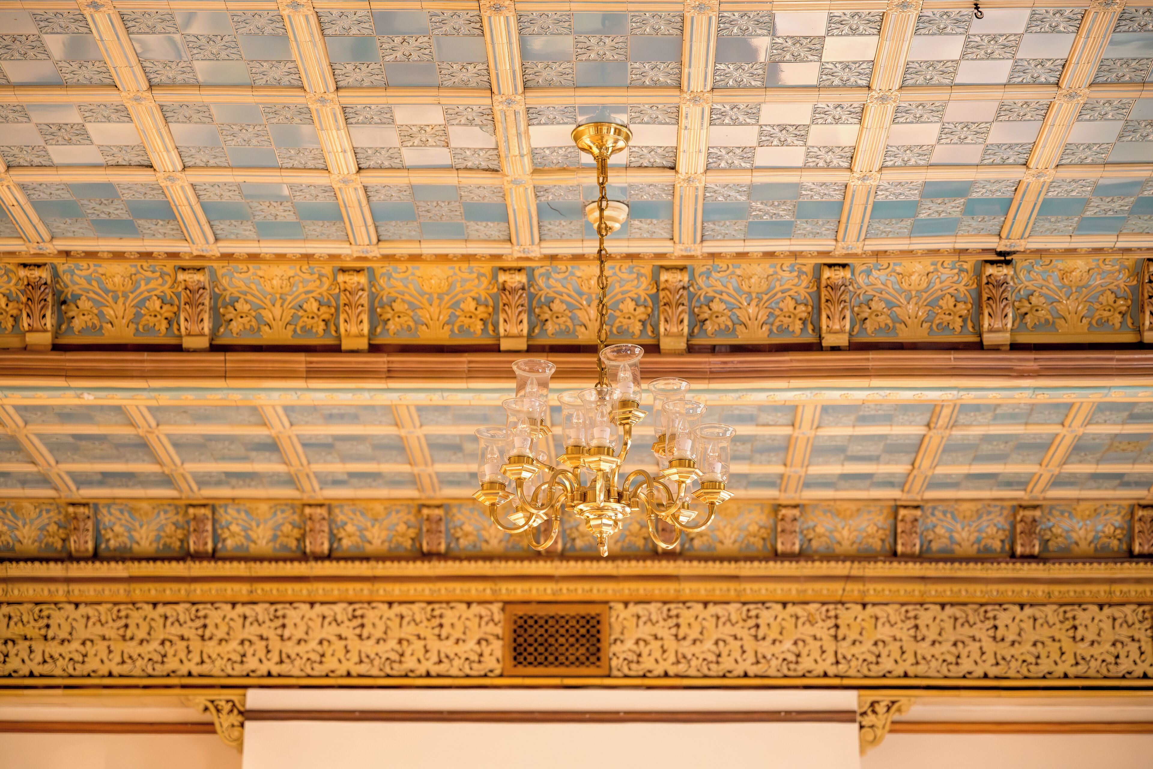 A ceiling with a geometric pattern and a chandelier.