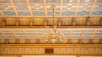 A ceiling with a geometric pattern and a chandelier.