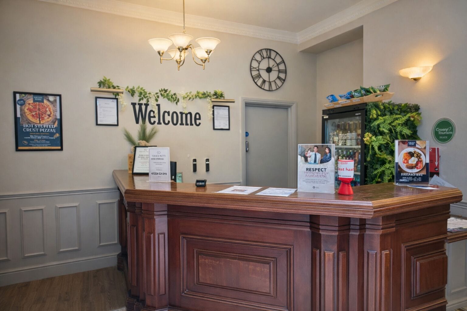 Un mostrador de recepción con un cartel de 'Welcome', certificados enmarcados, un reloj y un cartel que dice 'RESPECT'.
