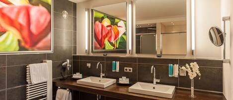 Un baño moderno con dos lavamanos, un espejo grande y un toallero calefactado.