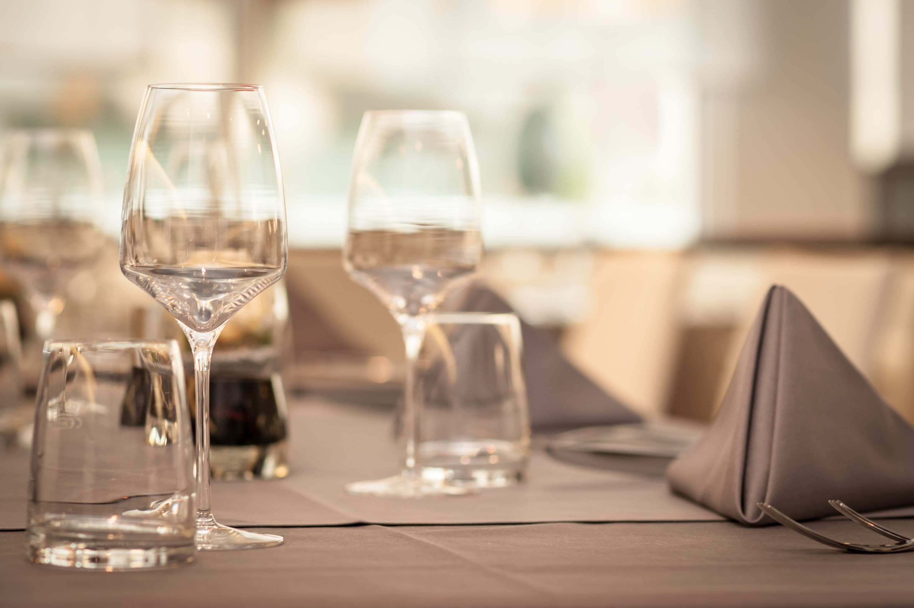 A table set with wine glasses and a napkin.